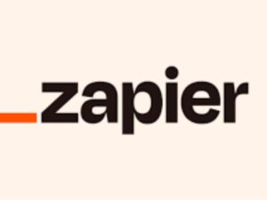 The Zapier logo, a web automation tool that enables users to automate workflows across various web applications, including Scheduling Tools for Social Media. The logo is represented by an orange horizontal line followed by the word 'Zapier' in lowercase and black font.