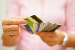 Image of a woman holding multiple credit cards, representing the concept of higher credit limits. With greater credit limits, individuals can access more purchasing power and financial flexibility.